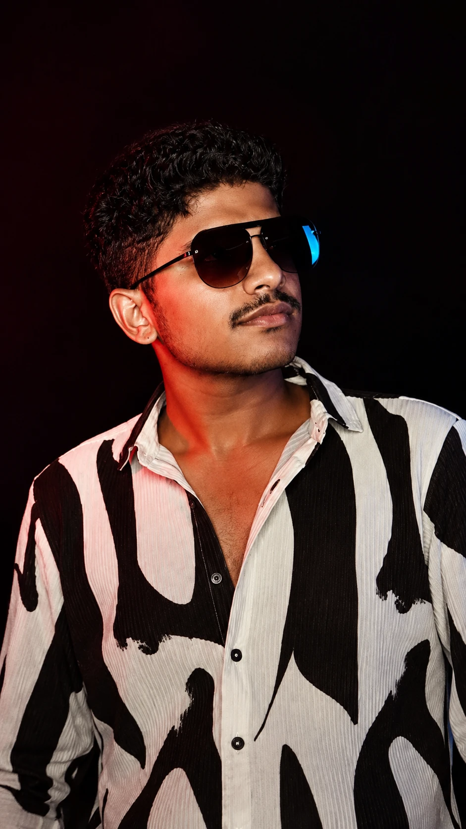 Homme sud-asiatique avec lunettes aviator et chemise à motif audacieux