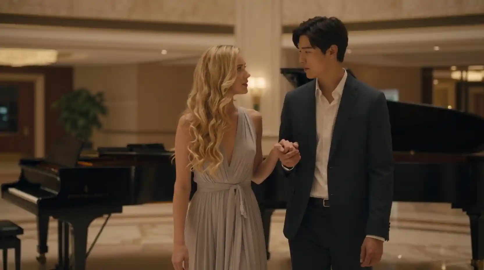 Pareja elegante en el atrio de un hotel con piano de cola