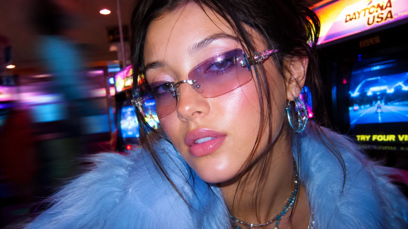 Retrato de chica con gafas de sol tintadas en un arcade nocturno