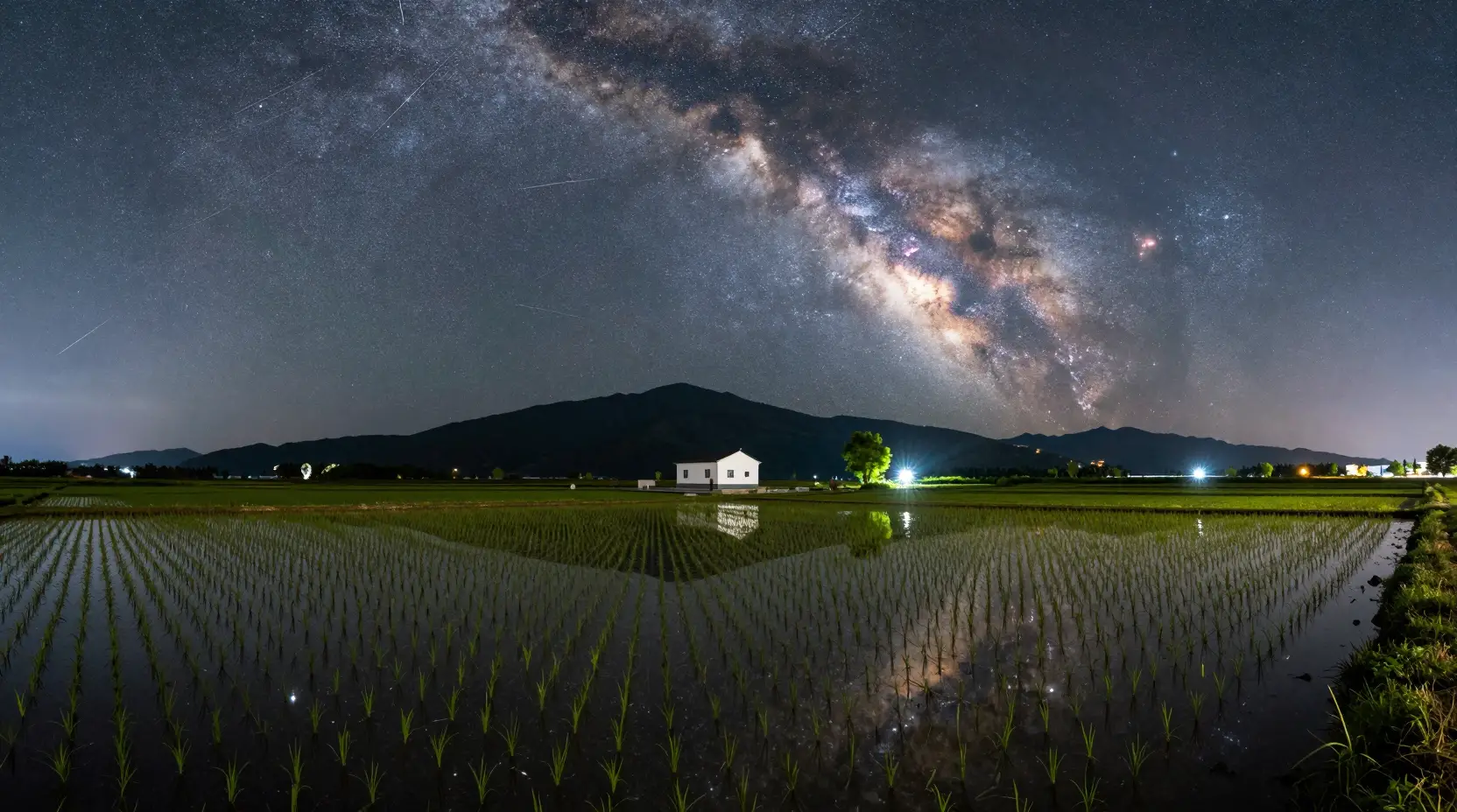 Starry Night Over Flooded Rice Fields And Distant Mountains