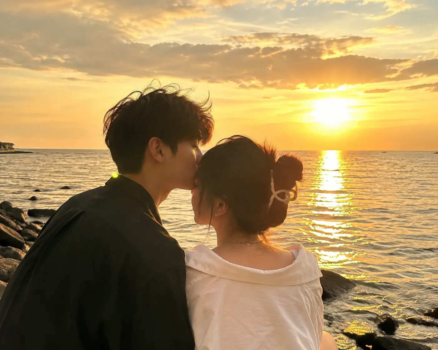 Pareja romántica junto al mar bajo el cálido brillo del sol