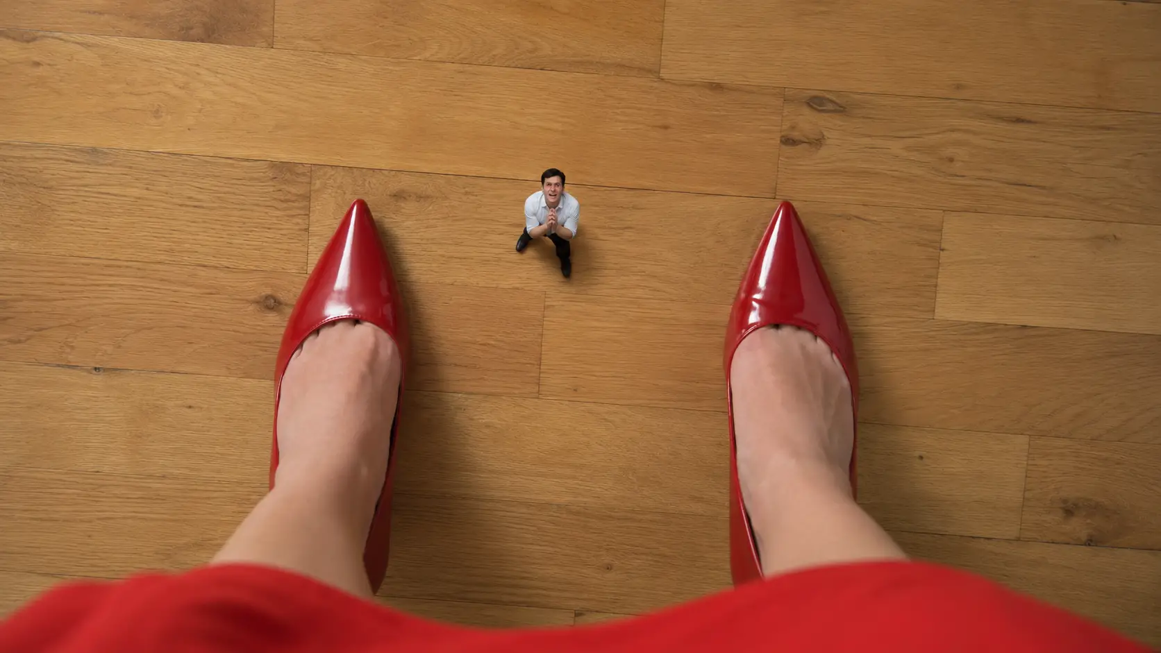 Top down view of woman finding tiny man on floor