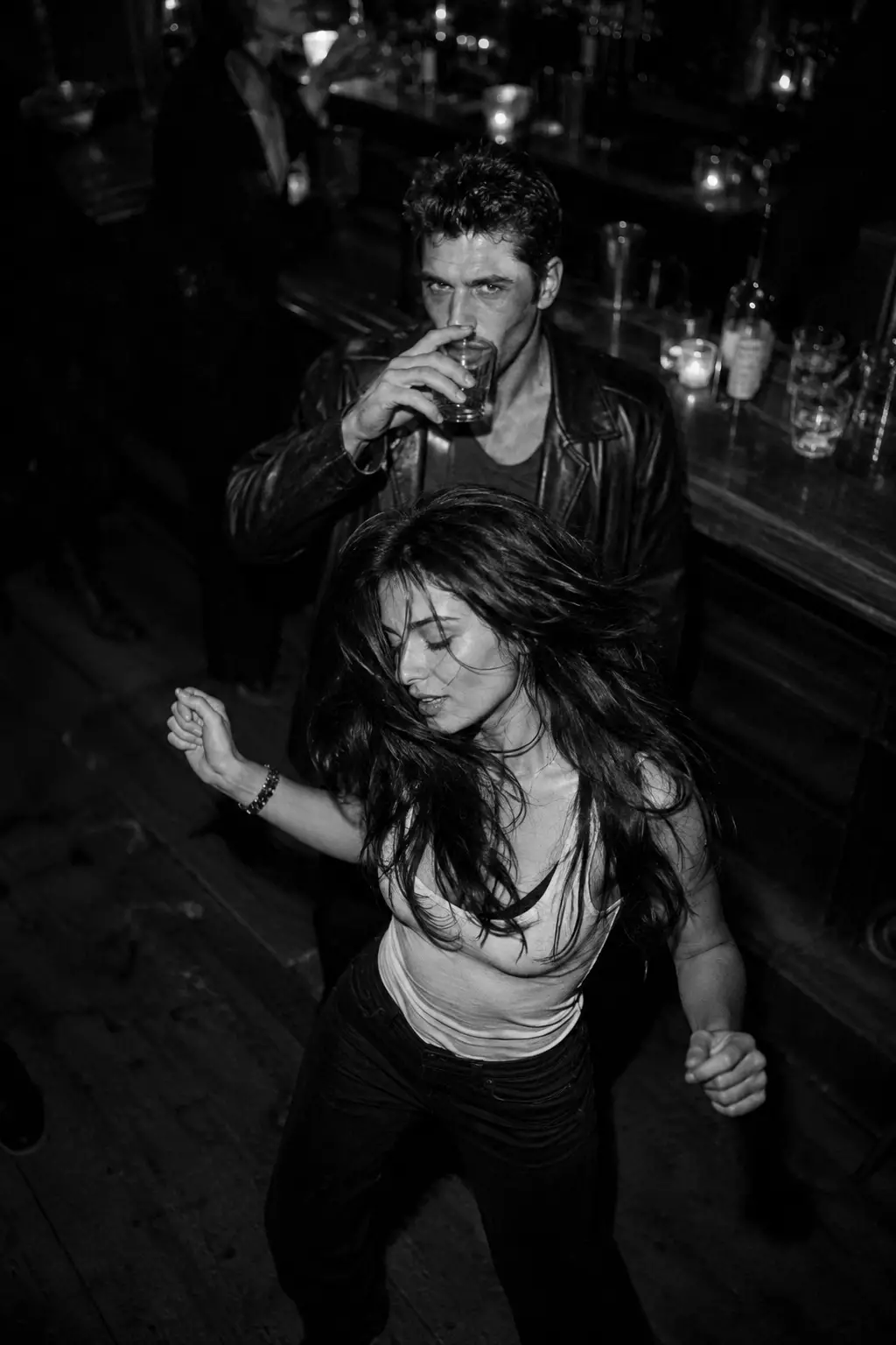 Frau tanzt nachts in einer monochromen Nachtclub‑Bar