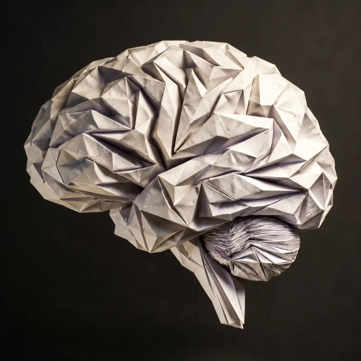 Sculpture de cerveau en origami flottant sur fond charbon sombre