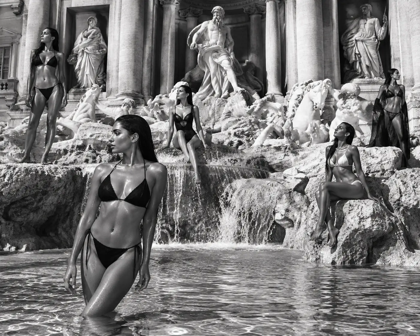 Women in swimwear posing at a grand Trevi fountain