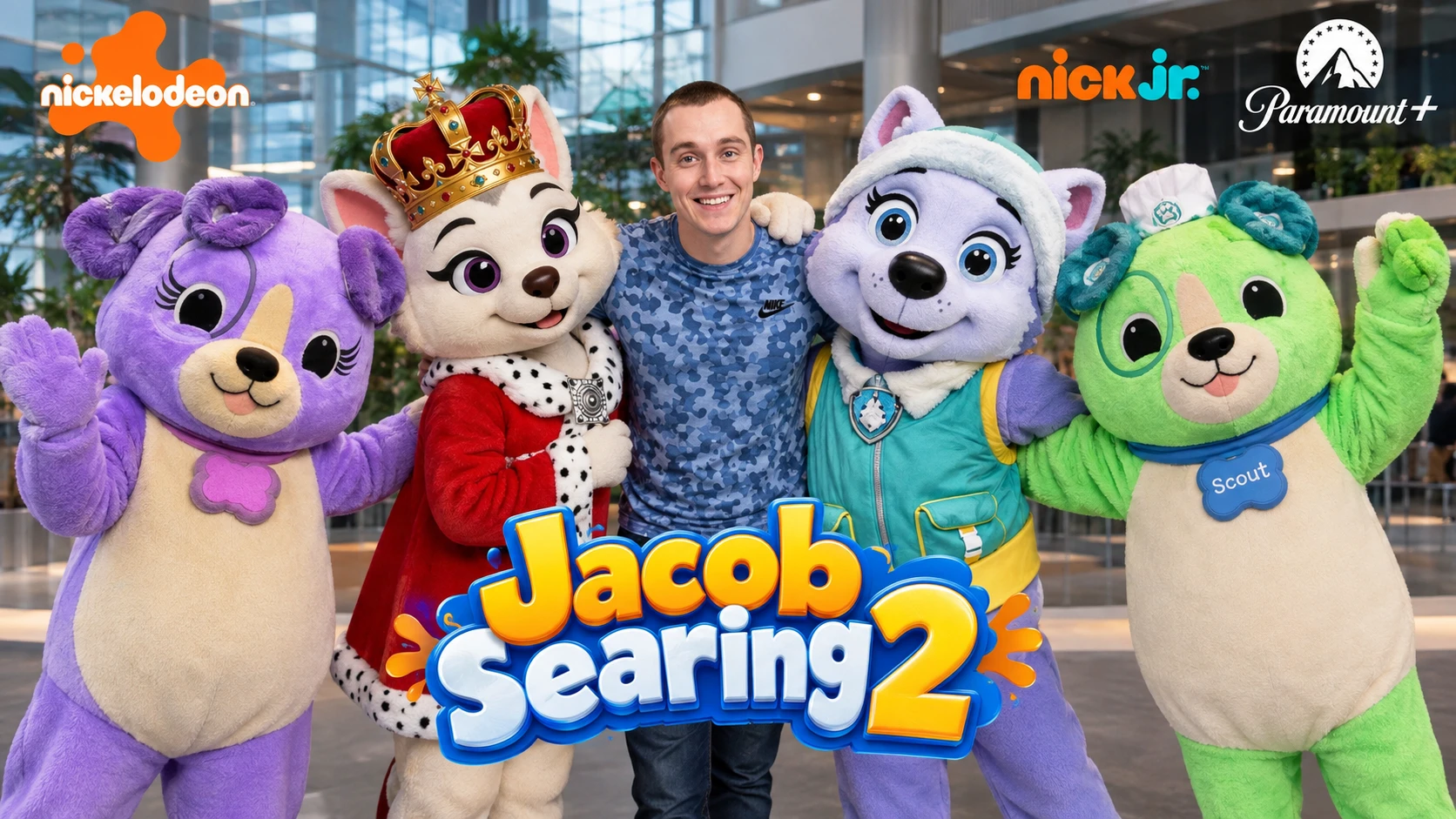 Adult man standing between four large friendly mascots