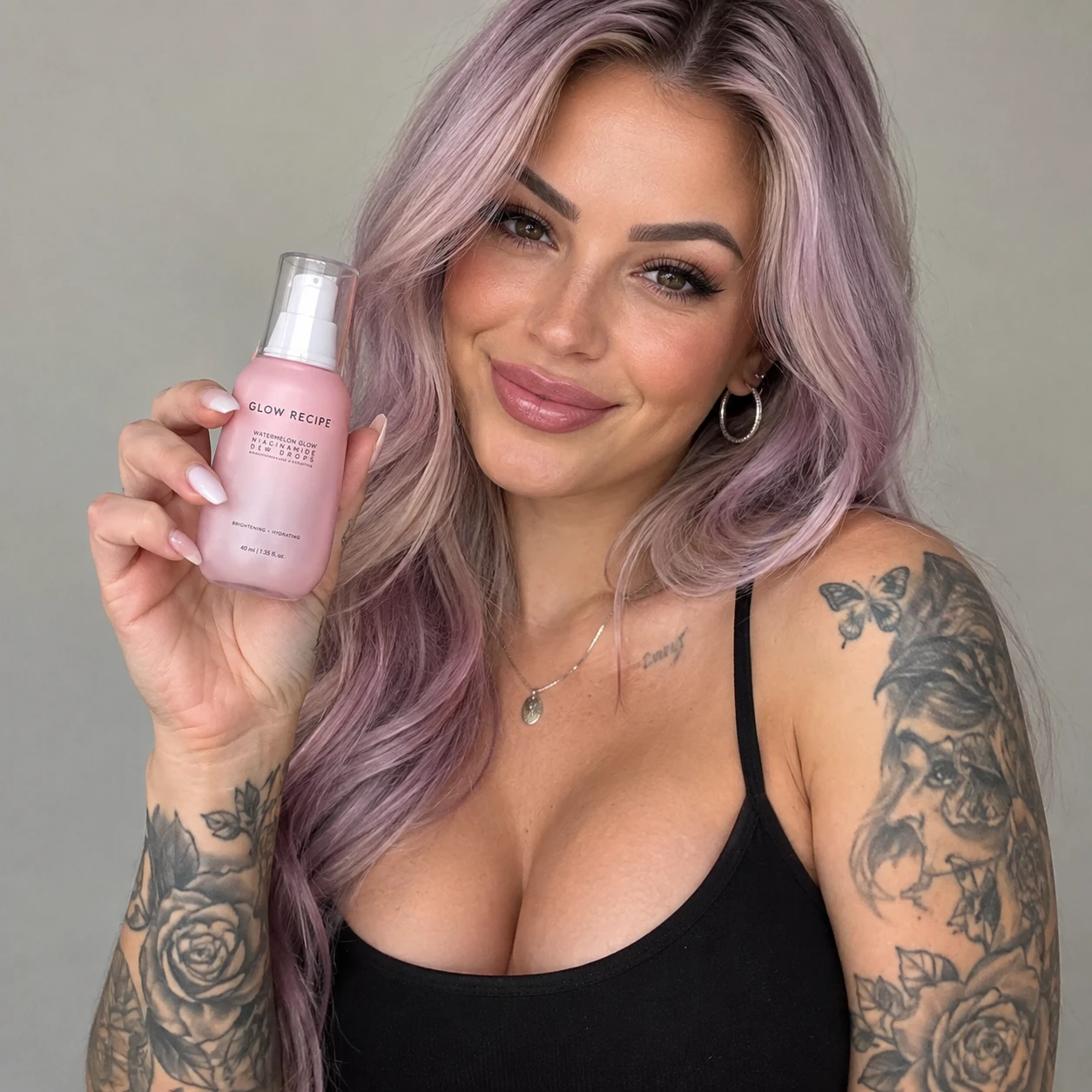 Mujer tatuada y segura de sí misma presentando un retrato con producto de belleza
