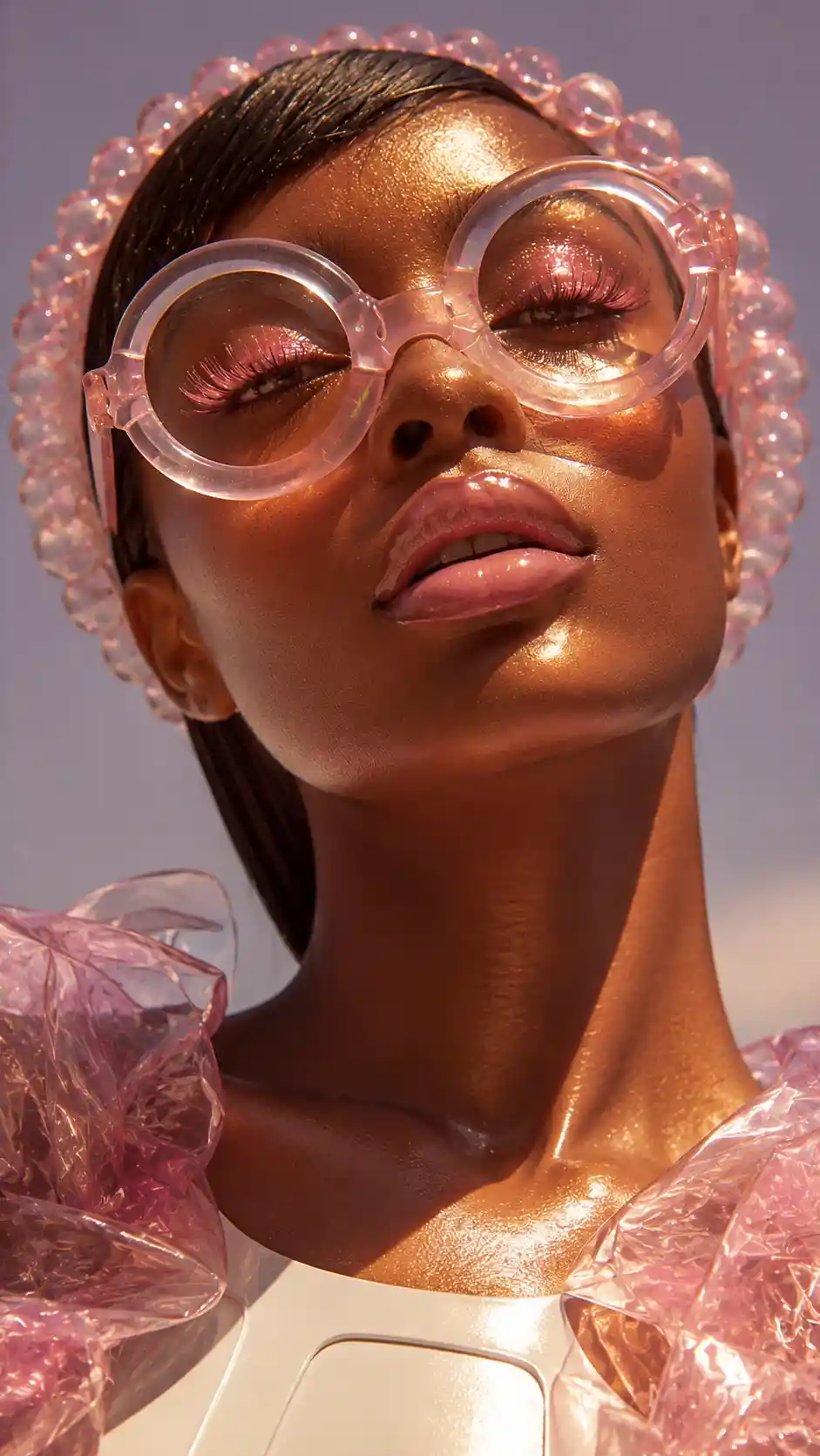 Portrait en gros plan d’une femme bronzée avec lunettes halo roses