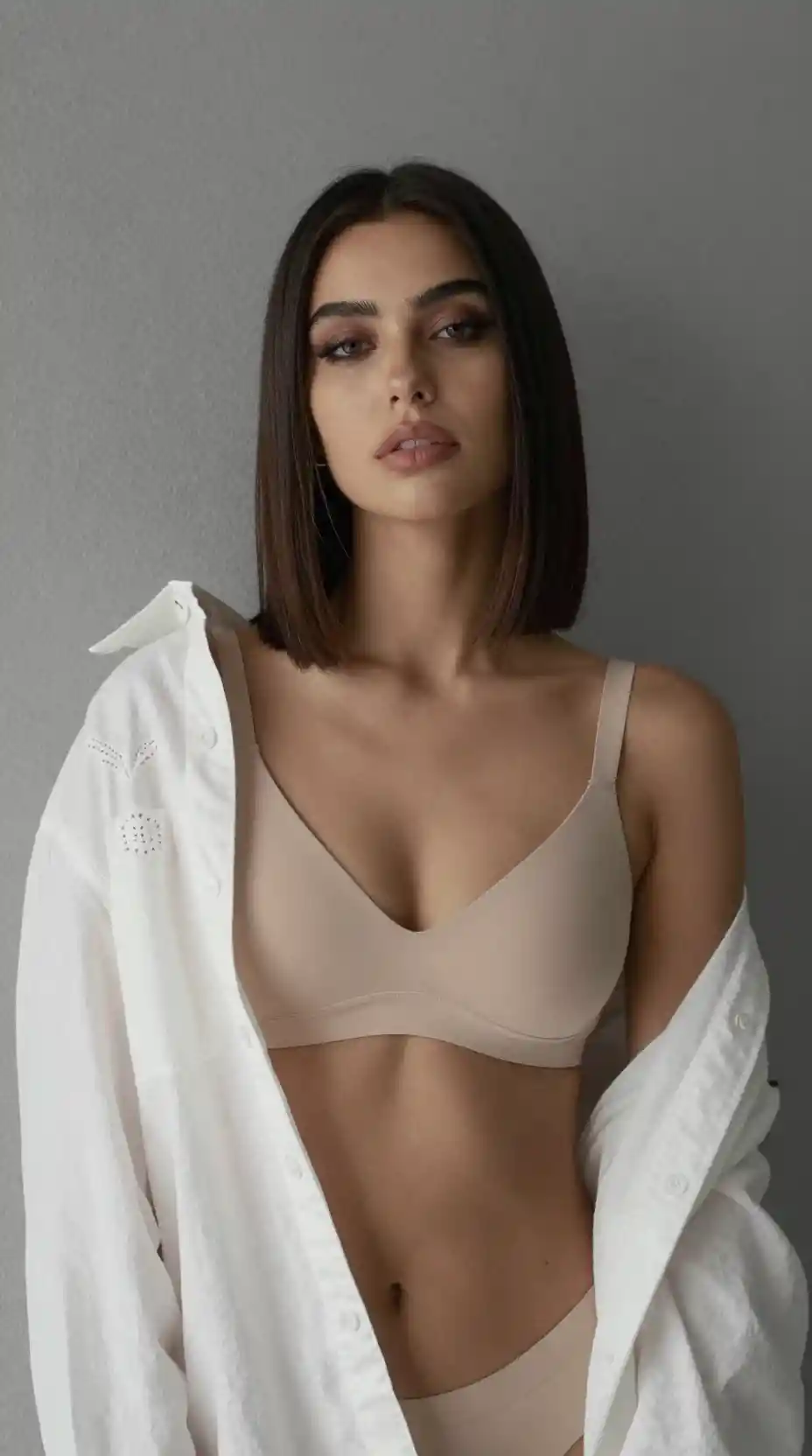 A fashion portrait with a beige bralette and embroidered shirt