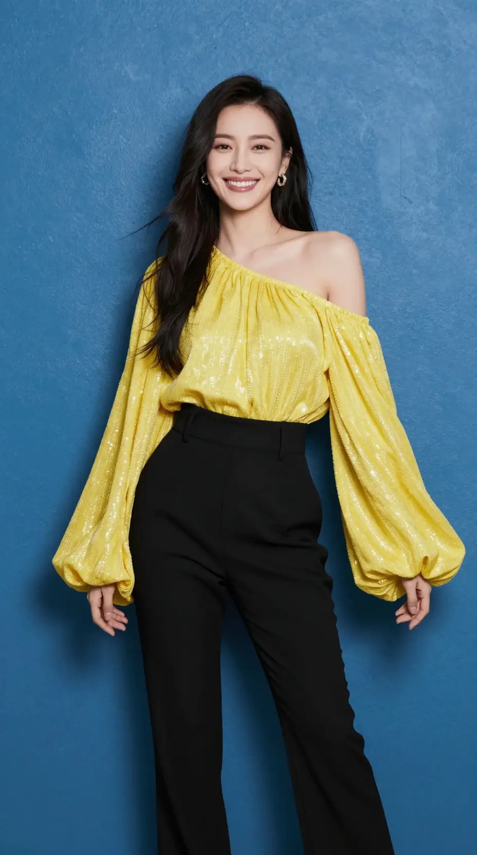 Uma mulher sorridente veste uma blusa amarela cintilante e calças pretas