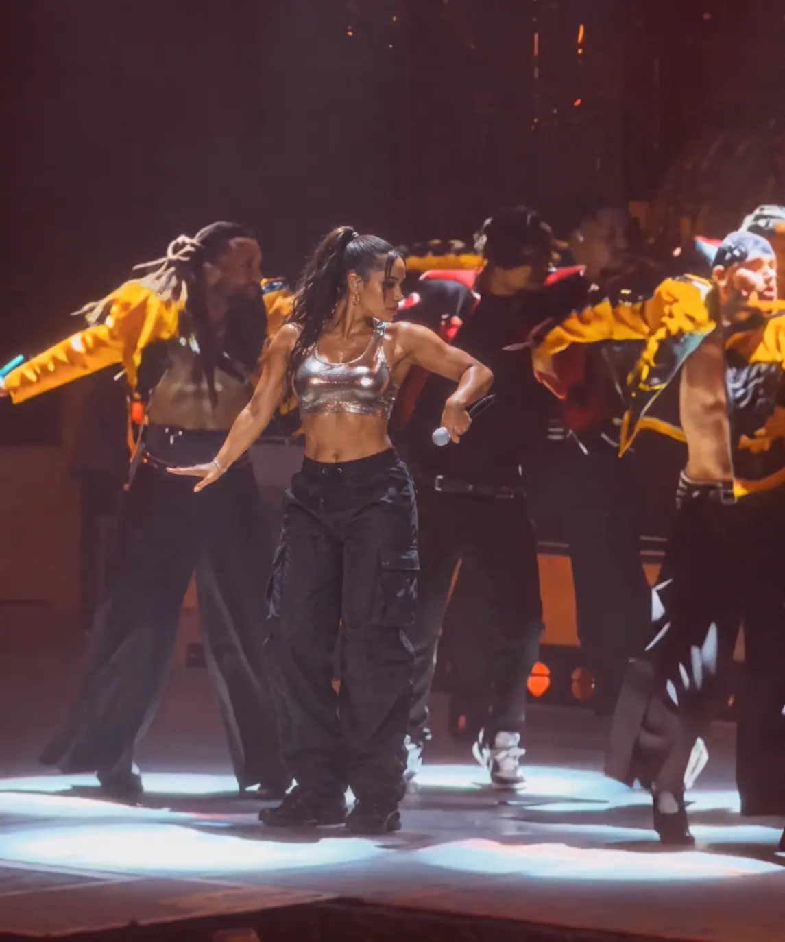 Create an AI video of a girl in a silver stage costume performing a “talk dirty” dance